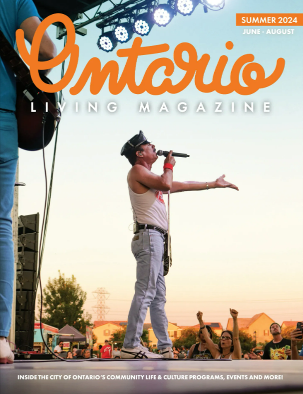 The cover features lead singer of Queen Nation, a Queen Tribute band singing to a crowd of Ontario Residents from the stage. The location is Celebration Park North during a beautiful sunset. 
